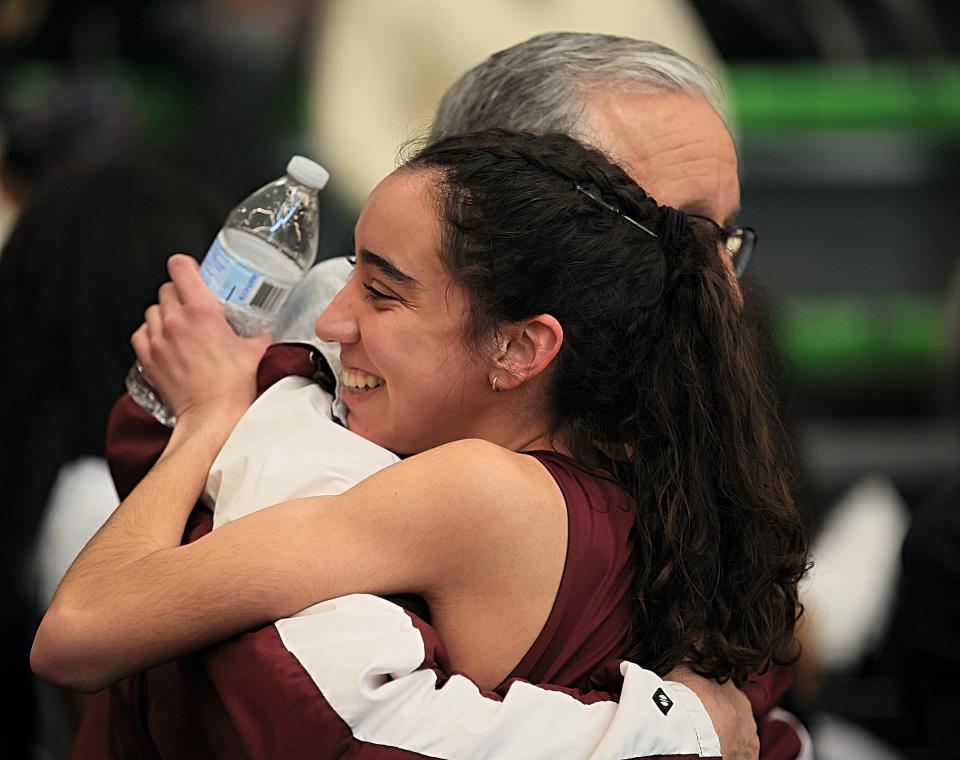 Remy Dubac of Clifton hugs her coach John Pontes after she broke the Passaic indoor 1,600 record at the State Meet of Champions March 5, 2023