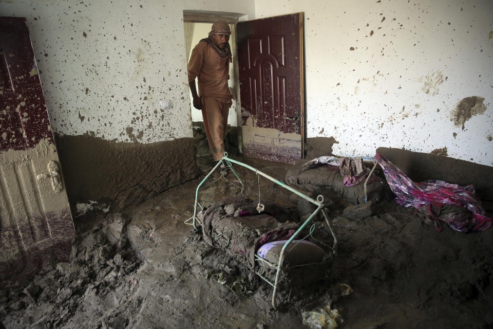 An Afghan man looks for belongings in his house that was damaged by a mudslide, in Parwan province, north of Kabul, Afghanistan, Thursday, Aug. 27, 2020. The death toll from heavy flooding in northern and eastern Afghanistan rose to at least 150 on Thursday, with scores more injured as rescue crews searched for survivors beneath the mud and rubble of collapsed houses, officials said. (AP Photo/Rahmat Gul)