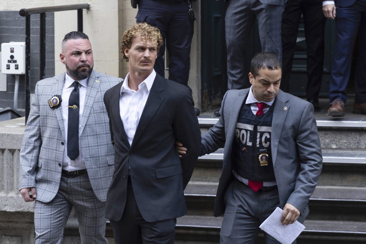 FILE – Daniel Penny, center, is walked by New York Police Department detectives out of the 5th Precinct on May. 12, 2023, in New York. Republican presidential hopefuls have rushed to support Penny, a white U.S. Marine veteran who was caught on video pinning an agitated Black subway passenger to the floor in a fatal chokehold.(AP Photo/Jeenah Moon, File)