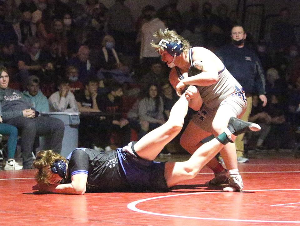 Mt. Anthony's Hayden Gaudette grabs the leg of Vergennes's Sam Martin during the 220 pound final at the State Championships on Sunday night at CVU.