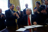 Dow Chemical CEO Andrew Liveris (L) reacts as U.S. President Donald Trump gives him the pen he used to sign an executive order on regulatory reform at his desk in the Oval Office at the White House, U.S. February 24, 2017. REUTERS/Jonathan Ernst