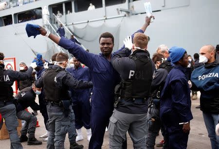 Migrants are inspected by policemen as they disembark the German naval vessel Frankfurt Am Main in the Sicilian harbour of Pozzallo, Italy, March 16, 2016. REUTERS/Antonio Parrinello