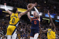 New York Knicks guard Donte DiVincenzo, center, drives to the basket between Indiana Pacers guard Tyrese Haliburton, left, and forward Aaron Nesmith, right, during the first half of Game 4 in an NBA basketball second-round playoff series, Sunday, May 12, 2024, in Indianapolis. (AP Photo/Michael Conroy)