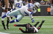 Dallas Cowboys running back Ezekiel Elliott (21) is tripped by Atlanta Falcons strong safety Damontae Kazee (27) during the first half of an NFL football game, Sunday, Nov. 18, 2018, in Atlanta. (AP Photo/Danny Karnik)