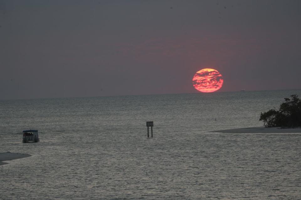 A sunset cruise enjoys the ball of fire before it sets on the horizon at New Pass on the south end of Lovers Key in Bonita Springs on Wednesday, April 3, 2019.