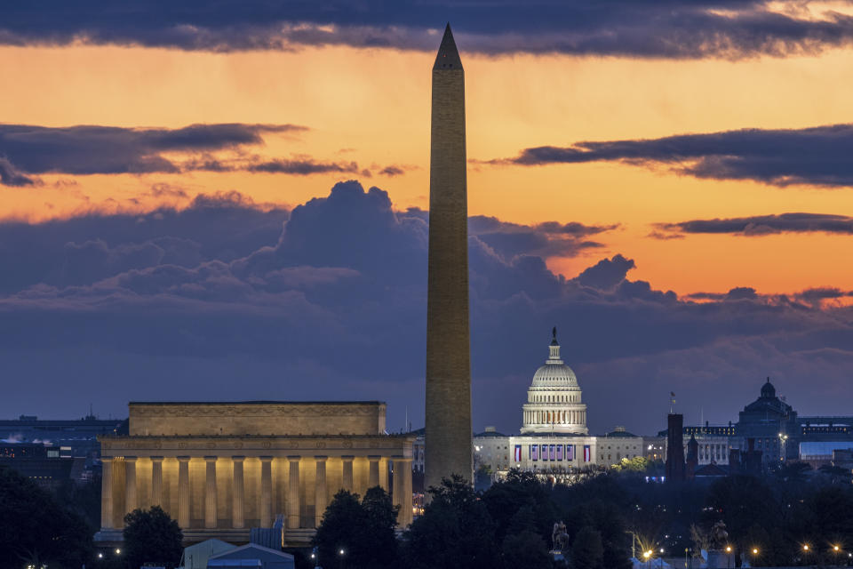 Dawn breaks behind the Lincoln Memorial, Washington Monument, and the U.S. Capitol on Inauguration Day in Washington, Wednesday, Jan. 20, 2021. President-elect Joe Biden will be sworn in as the 46th President of the United States of America at noon. (AP Photo/J. David Ake)