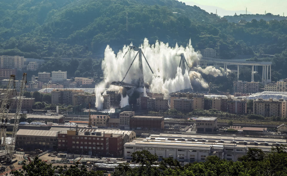 FILE - In this June 28, 2019 file photo, a cloud of dust rises as the remaining spans of the Morandi bridge are demolished in a planned explosion, in Genoa, Italy. The new bridge is being inaugurated Monday, Aug. 3, 2020. (AP Photo/Antonio Calanni)