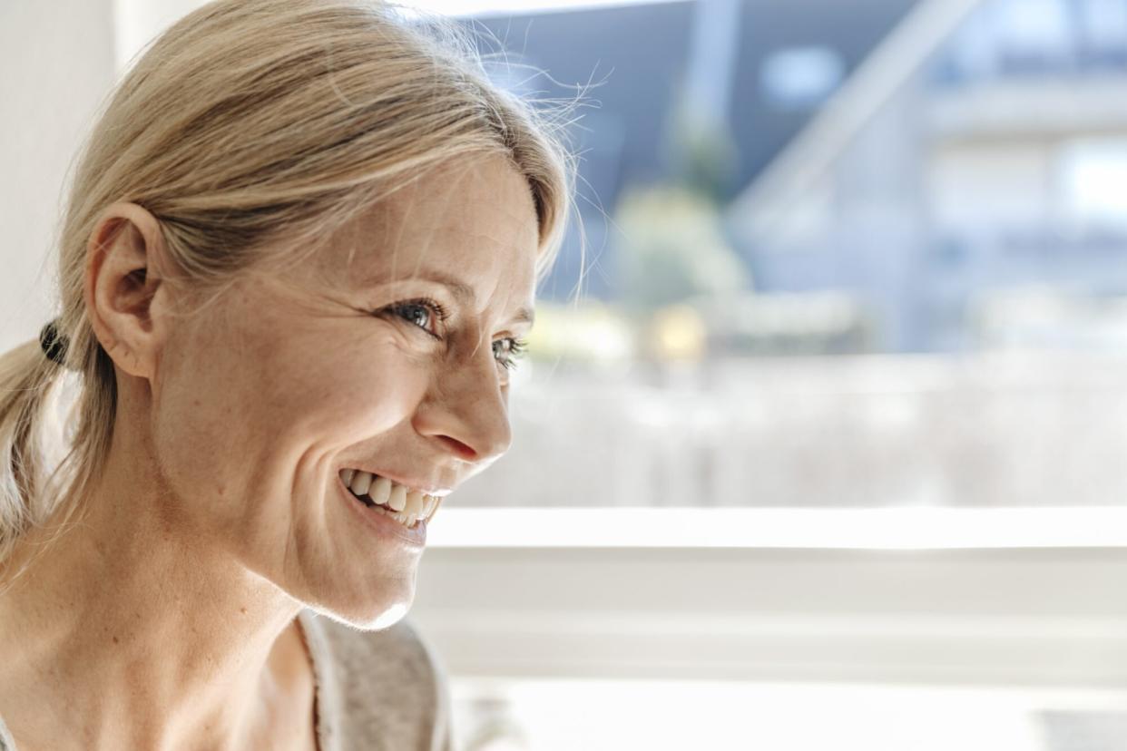 portrait of woman smiling near window