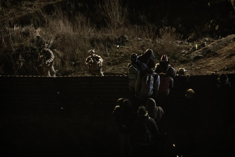 U.S. Border Protection officers point their weapons at migrants as they prepare to cross the border fence to get into the U.S. side to San Diego, Calif., from Tijuana, Mexico, Tuesday, Jan. 1, 2019. Discouraged by the long wait to apply for asylum through official ports of entry, many migrants from recent caravans are choosing to cross the U.S. border wall and hand themselves in to border patrol agents. (AP Photo/Daniel Ochoa de Olza)