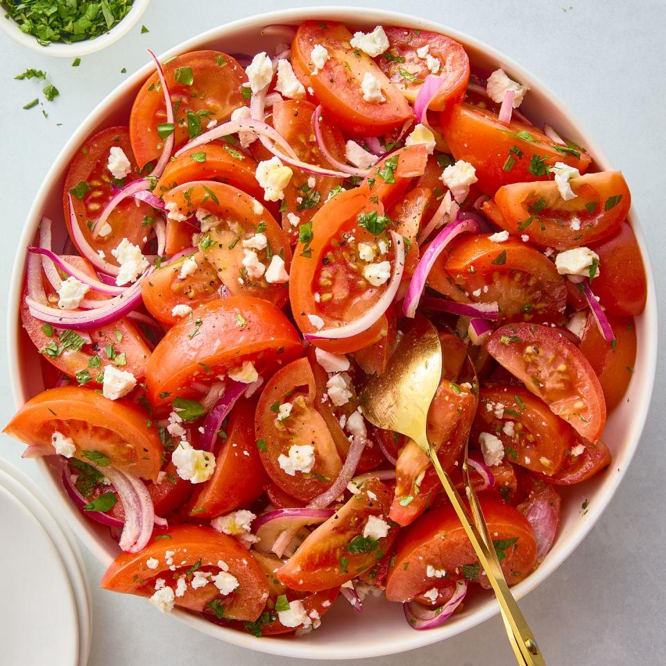 sliced tomatoes with red onions and feta and herbs