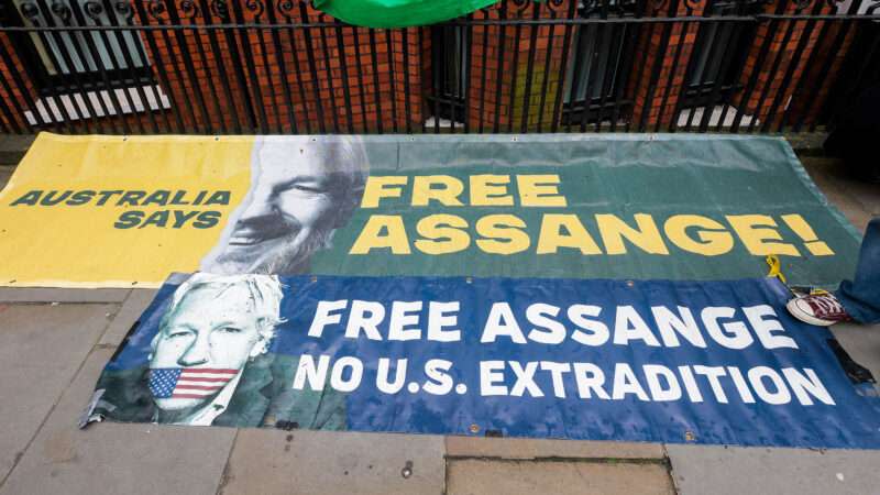 Signs on the sidewalk outside the Ecuadorian embassy in London that say FREE ASSANGE and NO U.S. EXTRADITION.