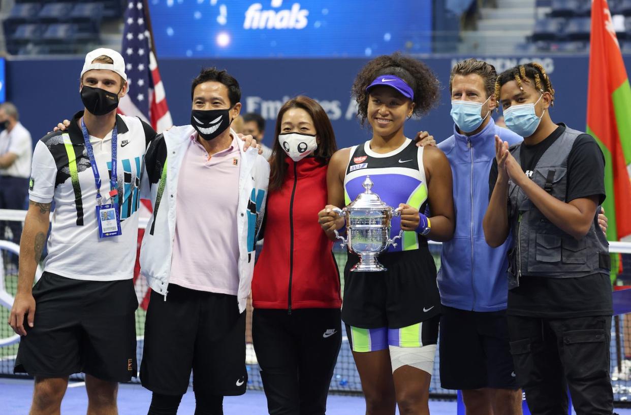 new york, new york   september 12 naomi osaka 3rd r of japan holds the trophy and celebrates with her team and boyfriend, rapper ybn cordae r, after winning her women's singles final match against victoria azarenka of belarus on day thirteen of the 2020 us open at the usta billie jean king national tennis center on september 12, 2020 in the queens borough of new york city photo by al bellogetty images