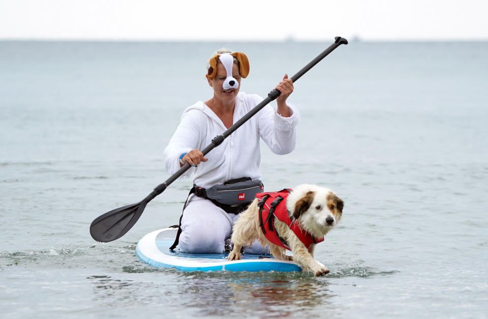 <p>Liz Wilkinson and her dog Diogie, a Sprollie cross, take part in Dogmasters, the country's only dog surfing and paddleboard championship, at Branksome Beach in Poole, Dorset. Picture date: Sunday July 25, 2021.</p>
