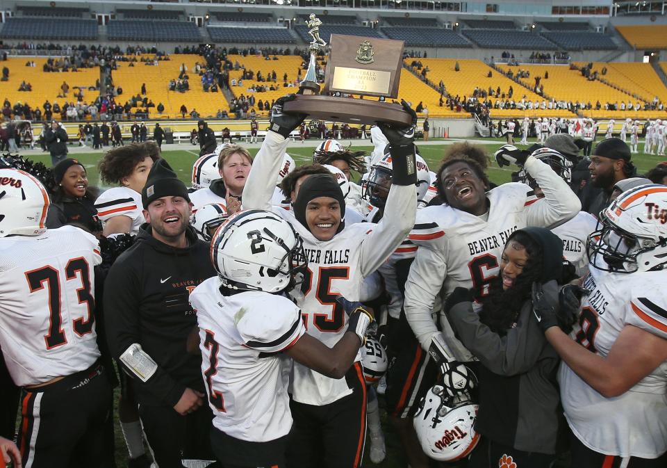 Beaver Falls Da'Sean Anderson (25) holds up the WPIAL 2A Championship trophy after the Tigers defeated Steel Valley 14-12 in WPIAL 2A Championship game Friday afternoon at Acrisure Stadium in Pittsburgh, PA.