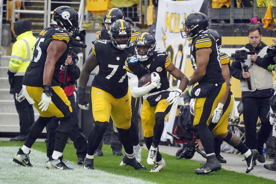 Pittsburgh Steelers wide receiver George Pickens (14) celebrates his score against the Jacksonville Jaguars with teammates, including offensive tackle Broderick Jones (77) during the second half of an NFL football game Sunday, Oct. 29, 2023, in Pittsburgh. (AP Photo/Gene J. Puskar)