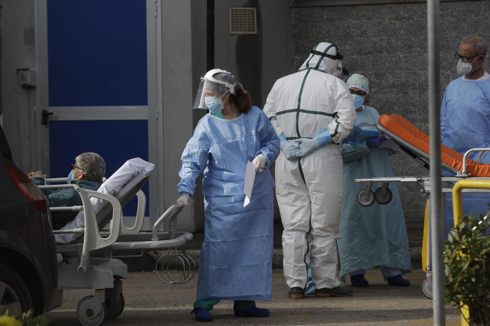 A paramedic carries a patient outside the first aid area of the Cardarelli hospital in Naples, Italy, Friday, Nov. 13, 2020. Italian Government and health officials were analyzing data to see if the hard-strapped Campania region, which includes Naples, should be declared a red-zone. (AP Photo/Gregorio Borgia)