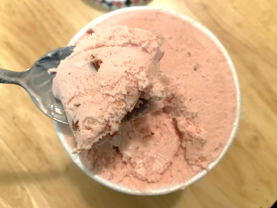 spoon scooping pink Trader Joe's strawberry oat ice cream in carton