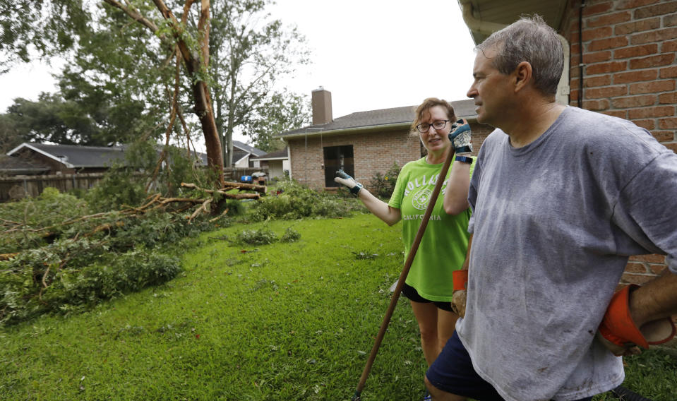 "At least it did not hit the house," says Lois Bergeron, left, Sunday, July 14, 2019, as she and her husband Steve Bergeron take a break from cleanup after Tropical Storm Barry and look at their downwd backyard tree, in Morgan City, La. (AP Photo/Rogelio V. Solis)