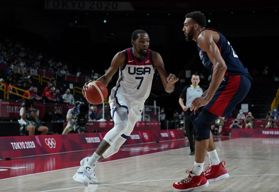 United States' Kevin Durant (7) drives around France's Rudy Gobert (27) during men's basketball gold medal game at the 2020 Summer Olympics, Saturday, Aug. 7, 2021, in Saitama, Japan. (AP Photo/Charlie Neibergall)