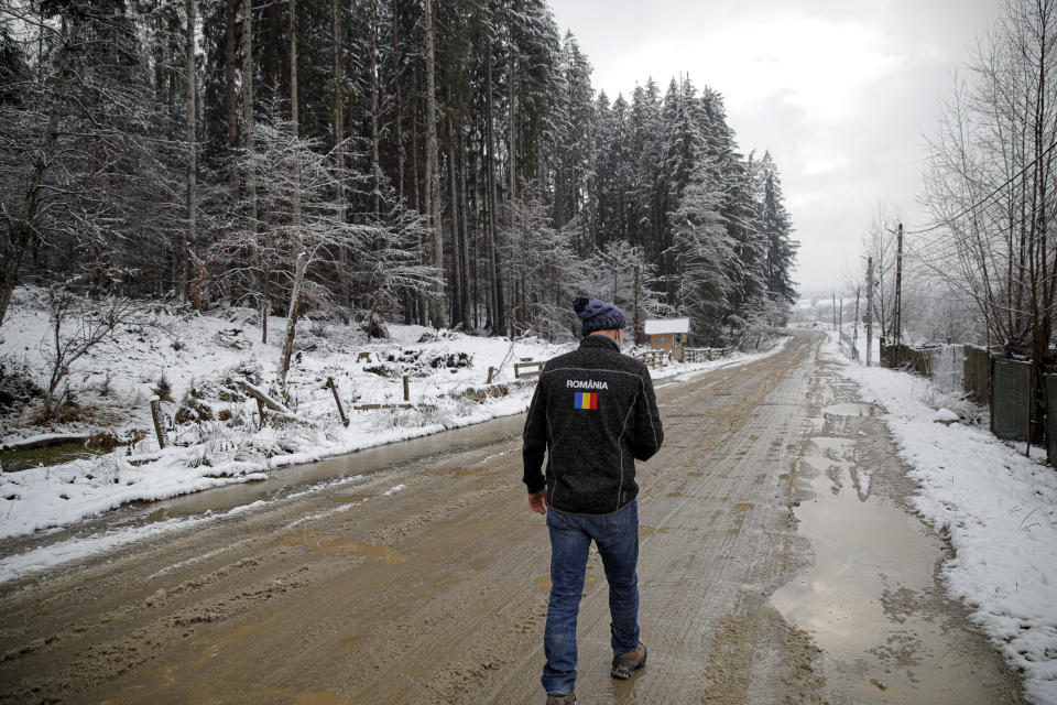 Valeriu Nicolae walks on a muddy road in Nucsoara, Romania, Saturday, Jan. 9, 2021. The rights activist has earned praise for his tireless campaign to change for the better the lives of the Balkan country’s poorest and underprivileged residents, particularly the children. (AP Photo/Vadim Ghirda)