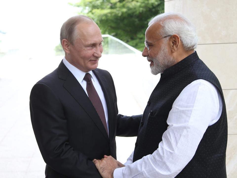 Vladimir Putin and Narendra Modi shake hands