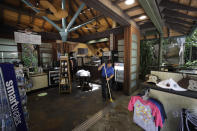 Workers clean a souvenir shop before the reopening of the San Diego Zoo, Thursday, June 11, 2020, in San Diego. California's tourism industry is gearing back up with the state giving counties the green light to allow hotels, zoos, aquariums, wine tasting rooms and museums to reopen Friday. (AP Photo/Gregory Bull)