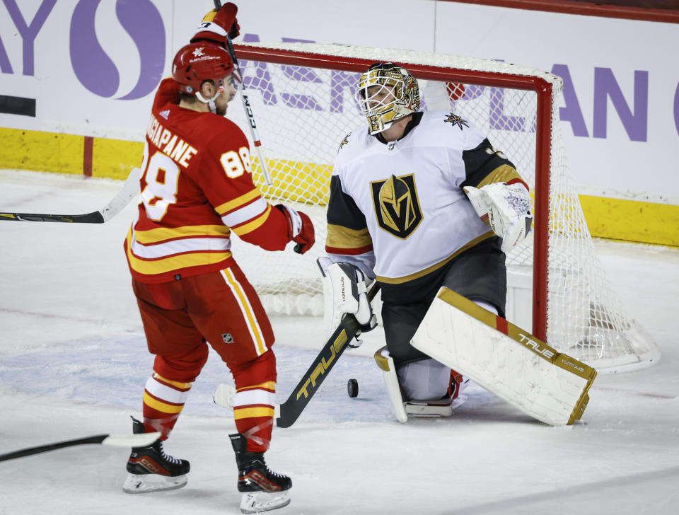 Vegas Golden Knights goalie Adin Hill, right, reacts as Calgary Flames forward Andrew Mangiapane celebrates victory during overtime of an NHL hockey game in Calgary, Alberta, Monday, Nov. 27, 2023. (Jeff McIntosh/The Canadian Press via AP)
