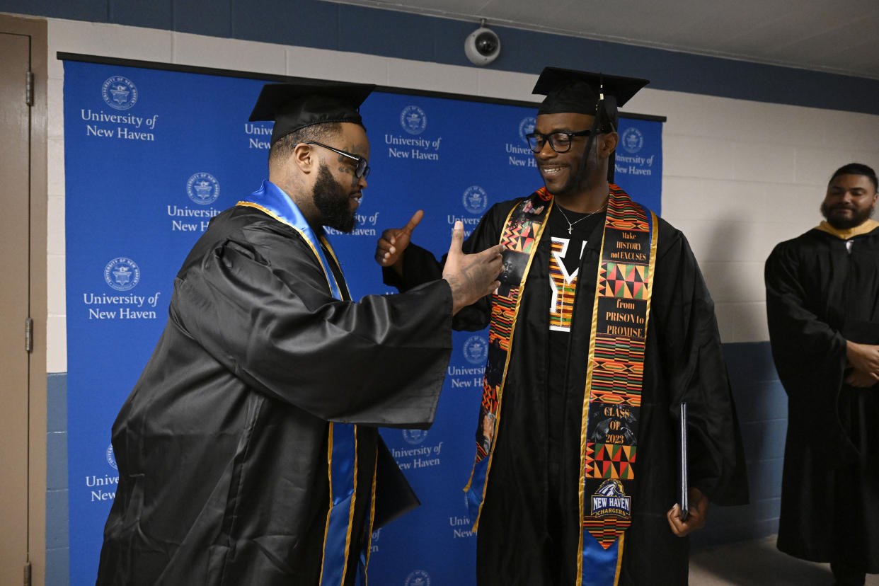 Graduates Alpha Jalloh, left, and Marcus Harvin, right, congratulate each other at graduation at the MacDougall-Walker Correctional Institution. 