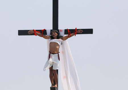 Ruben Enaje, 58, who portrays Jesus Christ, grimaces in pain after being nailed on a wooden cross during crucifixion re-enactment on Good Friday, in San Fernando City, Pampanga province, Philippines, April 19, 2019. REUTERS/Eloisa Lopez