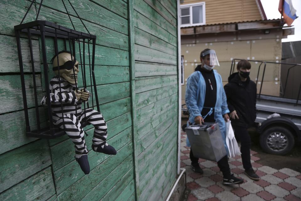 Two members of an election commission carry a ballot box while walking from house to house helping older villagers to vote during the Parliamentary elections in Nikolayevka village outside Omsk, Russia, Sunday, Sept. 19, 2021. Russia has begun the third day of voting for a new parliament that is unlikely to change the country's political complexion. There's no expectation that United Russia, the party devoted to President Vladimir Putin, will lose its dominance in the State Duma. (AP Photo/Evgeniy Sofiychuk)