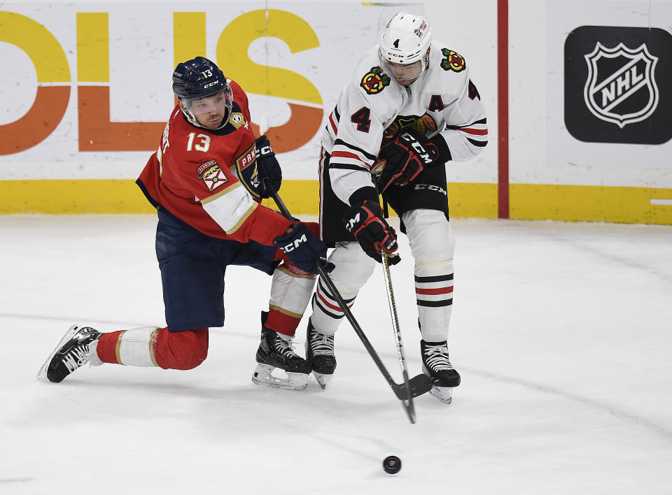 Florida Panthers center Sam Reinhart (13) shoots in front of Chicago Blackhawks defenseman Seth Jones (4) during the second period of an NHL hockey game, Friday, March 10, 2023, in Sunrise, Fla. (AP Photo/Michael Laughlin)