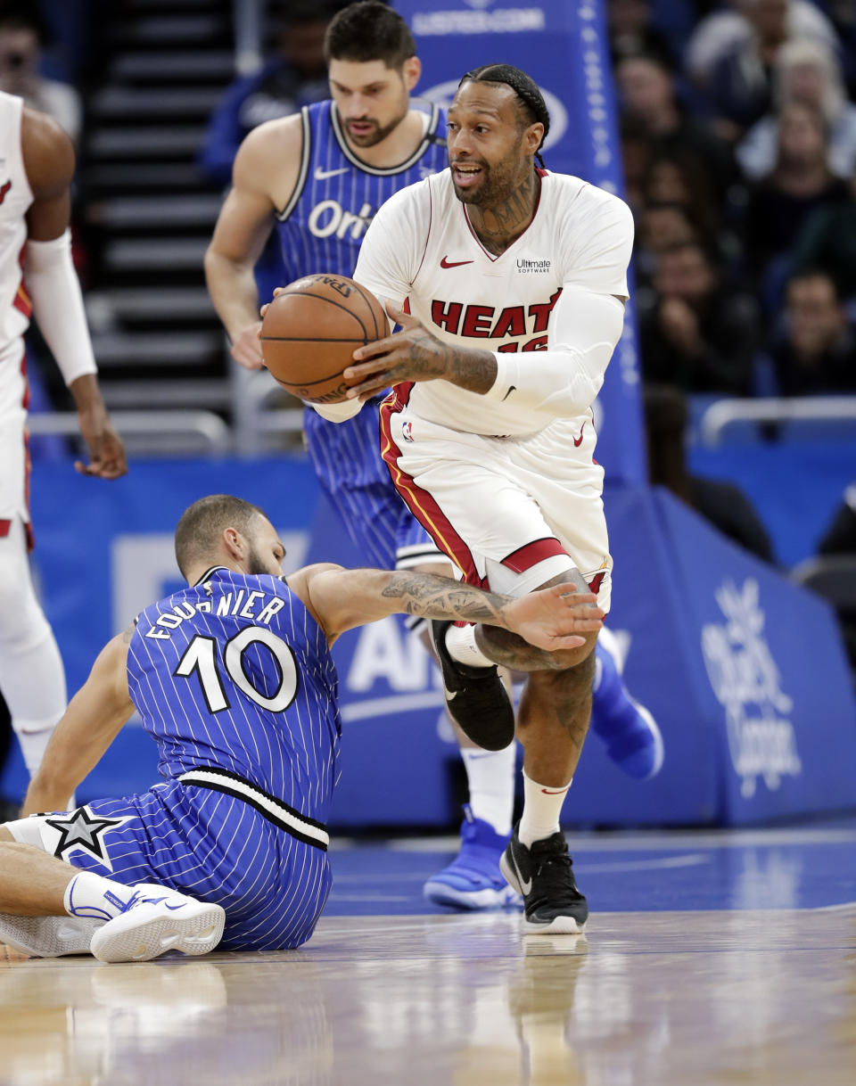 Miami Heat's James Johnson, right, moves past Orlando Magic's Evan Fournier (10) after scooping up a loose ball during the first half of an NBA basketball game, Sunday, Dec. 23, 2018, in Orlando, Fla. (AP Photo/John Raoux)