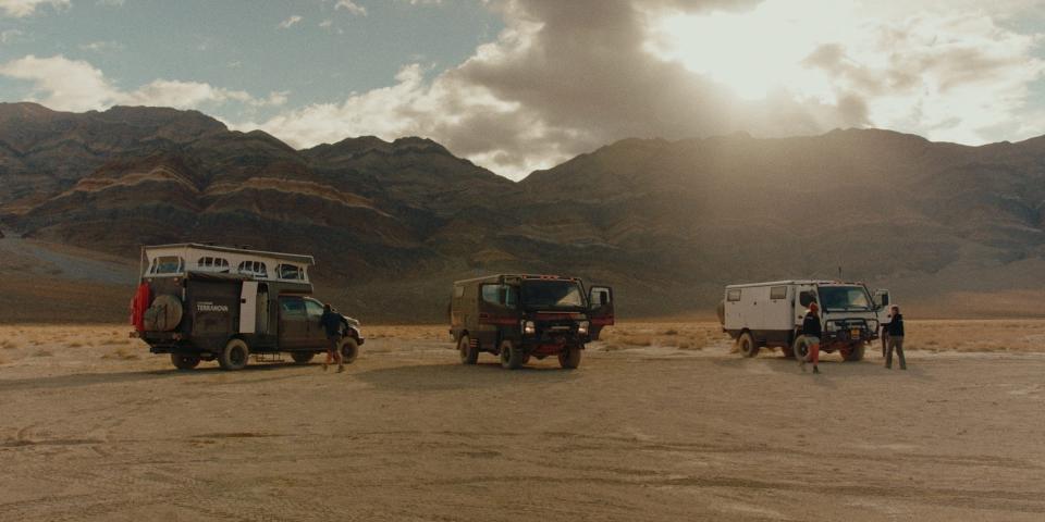 Three EarthCruiser RVs traveling in the desert.