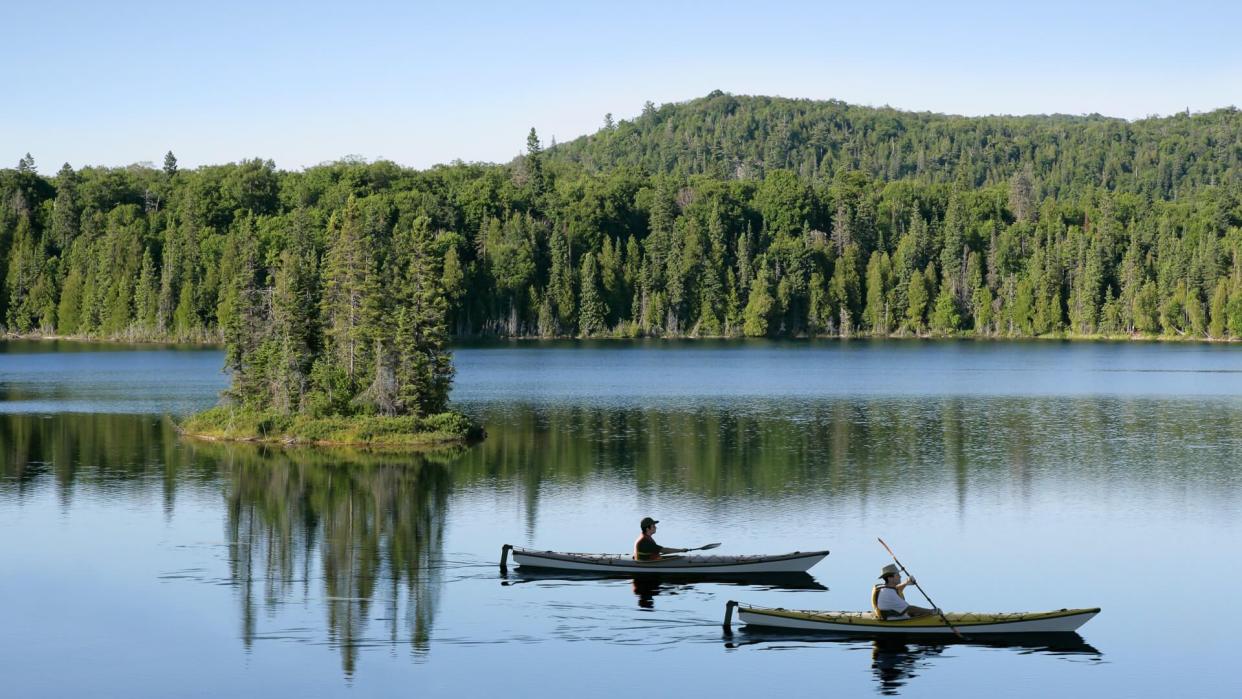 father and son kayaking on serene lake with bright sky (XXL).