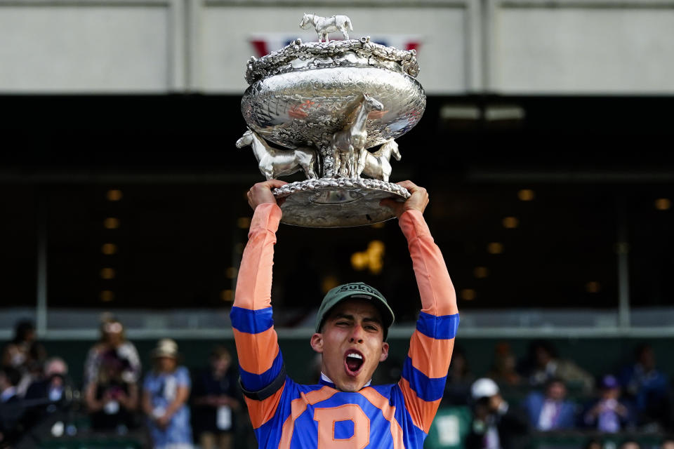 El jockey boricua Irad Ortiz Jr. alza el trofeo luego de montar a Mo Donegal, el caballo ganador de Belmont Stakes, el sábado 11 de junio de 2022, en Elmont, Nuea York (AP Foto/Frank Franklin II)