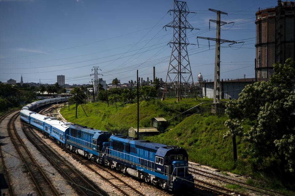 The first train using new equipment from China rides past, in Havana, Cuba, Saturday, July 13, 2019. The first train using new equipment from China pulled out of Havana Saturday, hauling passengers on the start of a 915-kilometer (516-mile) journey to the eastern end of the island as the government tries to overhaul the country’s aging and decrepit rail system. (AP Photo/Ramon Espinosa)