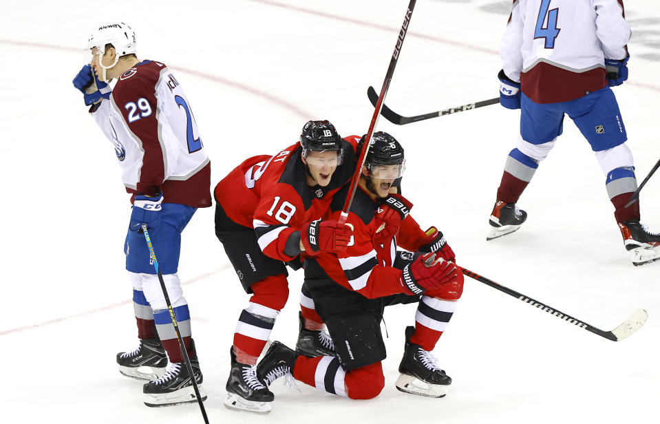 Colorado Avalanche center Nathan MacKinnon (29) looks away as New Jersey Devils defenseman John Marino reacts with left wing Ondrej Palat (18) after scoring a goal during the third period of an NHL hockey game, Tuesday, Feb. 6, 2024, in Newark, N.J. The New Jersey Devils won 5-3. (AP Photo/Noah K. Murray)