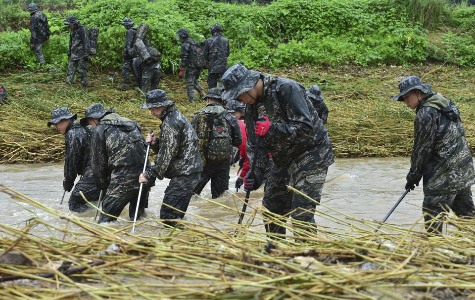 South Korean marines search for missing people in floodwaters in Yecheon, South Korea, Tuesday, July 18, 2023. Rescuers continued their searches Tuesday for people still missing in landslides and other incidents caused by more than a week of torrential rains. (Lee Moo-ryul/Newsis via AP)