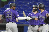 Colorado Rockies' Elehuris Montero (44) is congratulated by Brendan Rodgers (7) and Jordan Beck (27) after hitting a three-run home run during the first inning of a baseball game against the Miami Marlins104, Tuesday, April 30, 2024, in Miami. (AP Photo/Marta Lavandier)