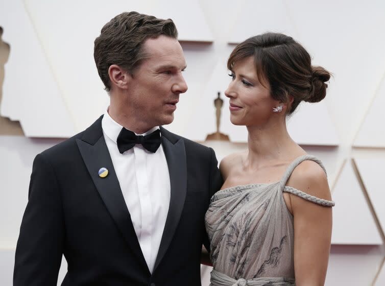 Actor Benedict Cumberbatch in a tuxedo looks toward his wife Sophie at a red-carpet event