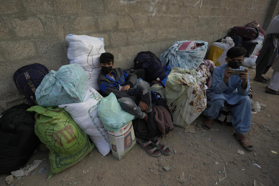 Varios afganos esperan un transporte para regresar a su país, en Karachi, Pakistán, el 30 de octubre de 2023. (AP Foto/Fareed Khan)
