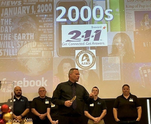 John Scott, director of Brevard County Emergency Management, backed by members of his team, speaks during a Friday celebration marking 211 Brevard's 60th anniversary and saluting community partners. Emegency Management was one of 211's "Milestone Partners" honored.