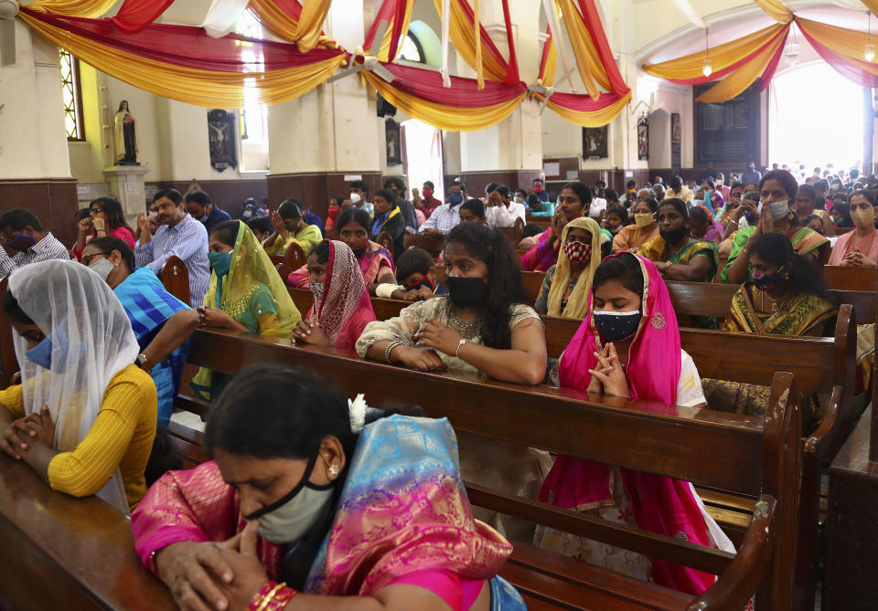 Indian Christians wearing face masks as a precaution against the coronavirus attend a Christmas mass at St. Joseph Cathedral in Hyderabad, India, Friday, Dec. 25, 2020. (AP Photo/Mahesh Kumar A.)