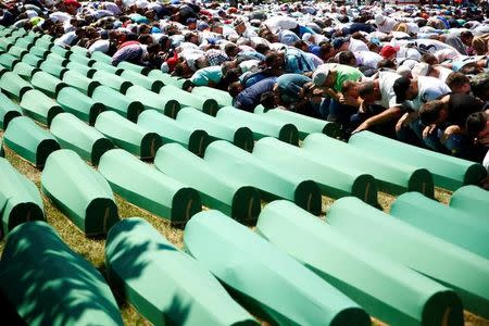 Muslim men pray in front of coffins during mass funeral in Potocari near Srebrenica, Bosnia and Herzegovina July 11, 2016. REUTERS/Dado Ruvic