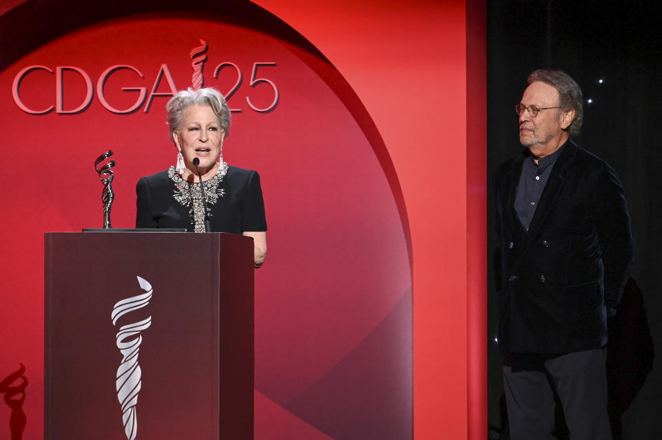 Bette Midler accepts the Distinguished Collaborator Award as Billy Crystal watches onstage at the 25th Costume Designers Guild Awards held at the Fairmont Century Plaza on February 27, 2023 in Los Angeles, California.