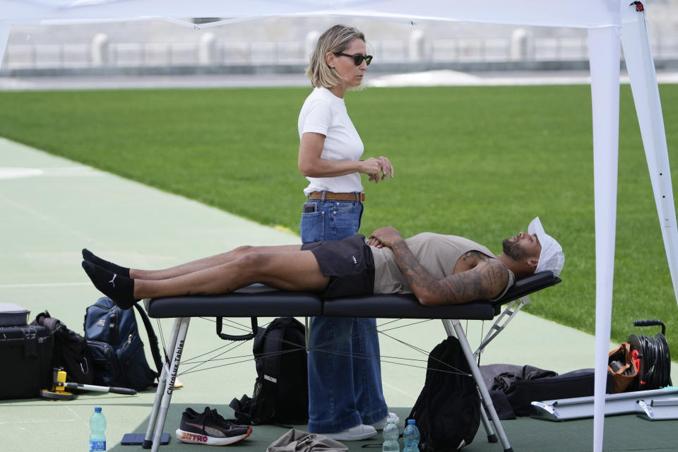 FILE - Defending Olympic 100 meters champion Marcell Jacobs listens to his mental coach Nicoletta Romanazzi during a training in the historic Stadio dei Marmi ahead of an athletics meeting, in Rome, Wednesday, May 15, 2024. Hardly anyone outside of Italy had heard of Marcell Jacobs before he succeeded Usain Bolt as the Olympic 100 meter champion in Tokyo. Three injury-filled years have passed, and the Texas-born Italian is almost as big of a mystery now as he was then. (AP Photo/Alessandra Tarantino, file)