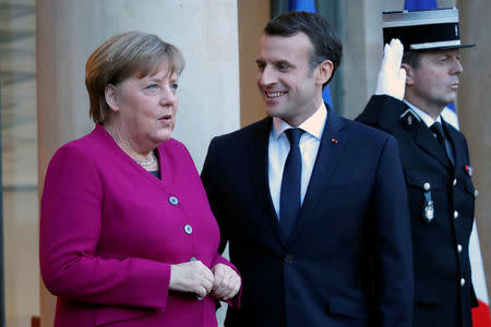 French President Emmanuel Macron (R) greets German Chancellor Angela Merkel upon her arrival at the Elysee Palace in Paris, France, January 19, 2018. REUTERS/Charles Platiau