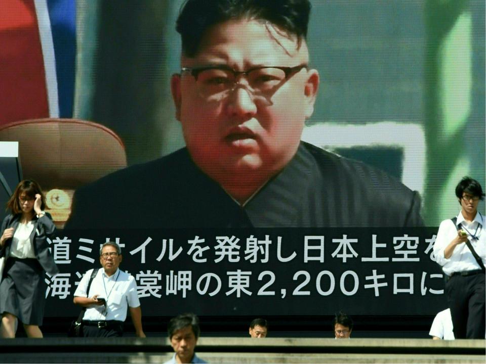 Pedestrians walk in front of a large video screen in Tokyo broadcasting a news report showing North Korean leader Kim Jong-Un: TORU YAMANAKA/AFP/Getty Images