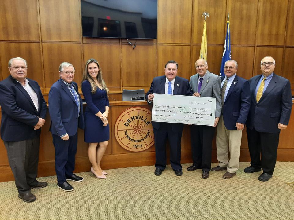 Mayor Tom Andes, middle left, and Morris County Commissioner John Krickus hold a ceremonial check representing the final $1.2 million payment from Denville to the Morris County Improvement Authority on a $13.5 million bond issued in 2007 to fund construction of a new municipal building,