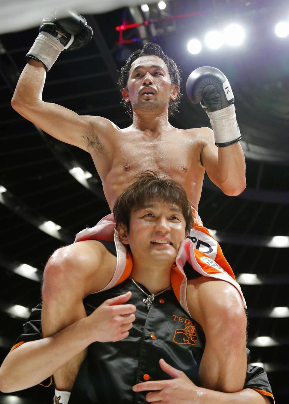 Japanese champion Shinsuke Yamanaka is carried on the shoulders of his corner's man after defeating Belgian challenger Stephane Jamoye in their WBC bantamweight boxing title bout in Osaka, western Japan, Wednesday, April 23, 2014. Yamanaka defended his title with a technical knockout in the ninth round. (AP Photo/Kyodo News) JAPAN OUT, CREDIT MANDATORY